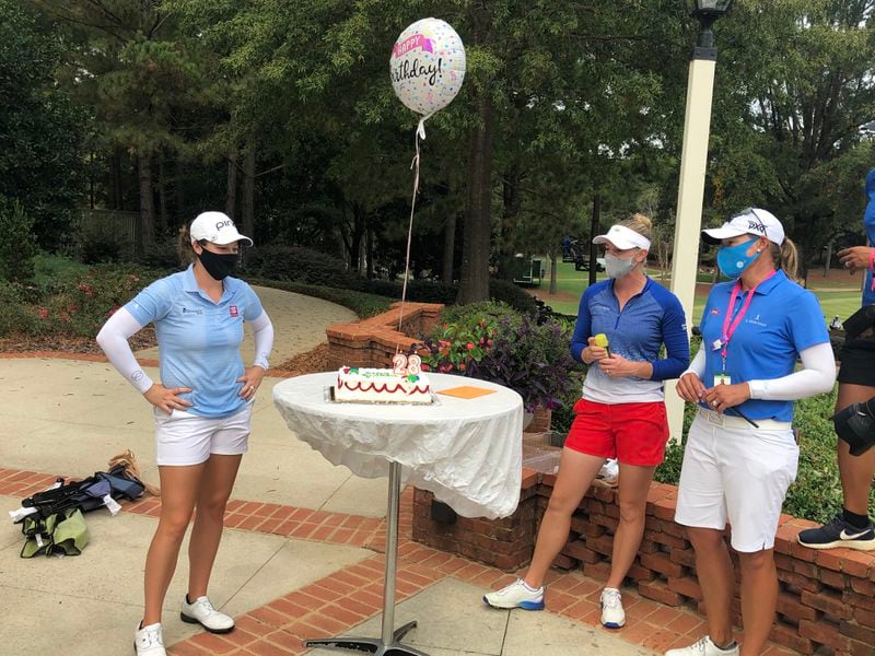 After LPGA win, golfer Ally McDonald (left), gets a celebratory birthday day cake from Amy Olson (center) and Katherine Kirk.  (Stan Awtrey/For the AJC)