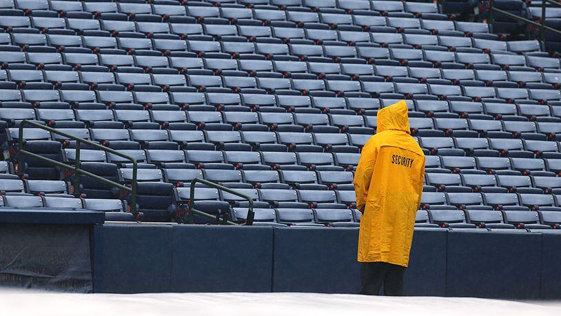 A security guard waits out a rain delay at Turner Field for the Braves against the Padres Thursday, June 11, 2015, in Atlanta.