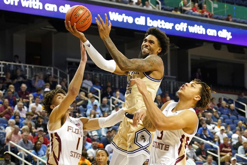 Georgia Tech forward Javon Franklin (4) drives between Florida State guard Jalen Warley (1) and Cam Corhen (3) during the second half of an NCAA college basketball game at the Atlantic Coast Conference Tournament in Greensboro, N.C., Tuesday, March 7, 2023. (AP Photo/Chuck Burton)