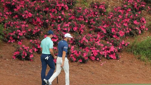 April 3, 2017, Augusta: Gary Woodland and Dustin Johnson walk past some of the few blooming azaleas on their way to the 12th green during their practice round for the Masters at Augusta National Golf Club on Monday, April 3, 2017, in Augusta. Curtis Compton/ccompton@ajc.com