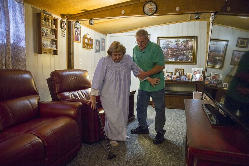 10/25/2019 — Warrenville, S.C. — Carl Durden (right) helps his wife, Sheryl Durden gain a slow but steady walking pace as they travel to their bedroom at their residence in Warrenville, Friday, October 25, 2019. Sheryl spends most of her time in her recliner or in her bed due to severe physical pain. She has been prescribed three Methadone pills and two OxyCodone pills, per day, to treat her pain. Sheryl has severe arthritis, stenosis, neuropathy and has had both knees replaced. Carl takes care of Sheryl and their household. (Alyssa Pointer/Atlanta Journal Constitution)