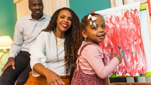 The McCown family is busy with their 2-year-old Priya McCowan, who turns three in early March and just added to her painting at their home.  Emanuel and Penelope McCowan struggled for years with fertility issues. Penelope now has a blog and a small business to help others in her situation.  (Jenni Girtman for The Atlanta Journal-Constitution)