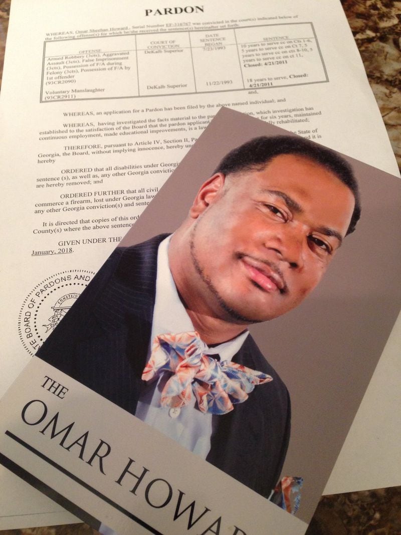 Omar Howard’s book cover lies atop the pardon he recently received for crimes he committed while a teenager. Today he is 43, a prison chaplain and motivational speaker. GRACIE BONDS STAPLES/ GSTAPLES@AJC.COM