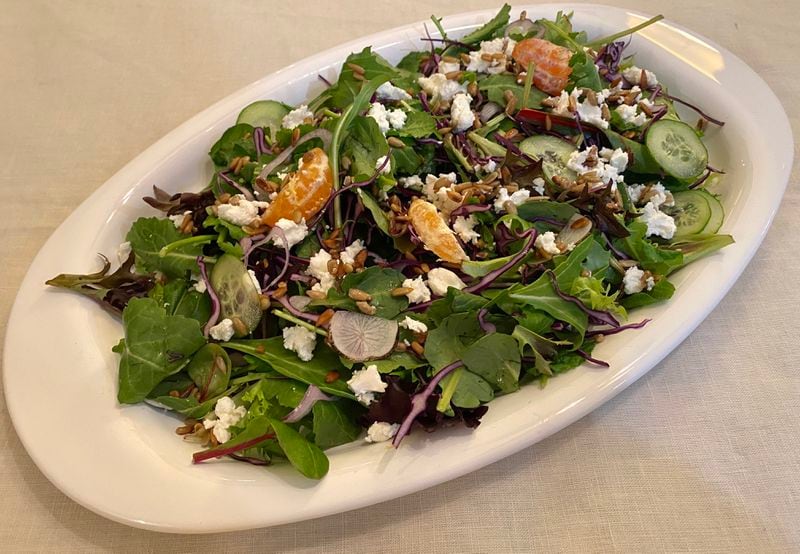 A salad from Mercer Street Meals includes a mix of fresh lettuce leaves, slivers of black radish and cucumber, mandarin orange wedges, red cabbage, goat cheese and sunflower seeds. Ligaya Figueras/ligaya.figueras@ajc.com
