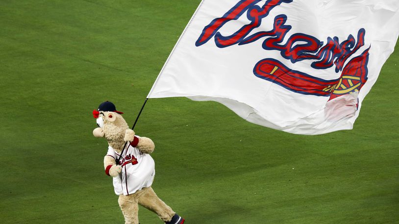 Braves mascot Blooper runs the team flag across the field. ALYSSA POINTER/ALYSSA.POINTER@AJC.COM