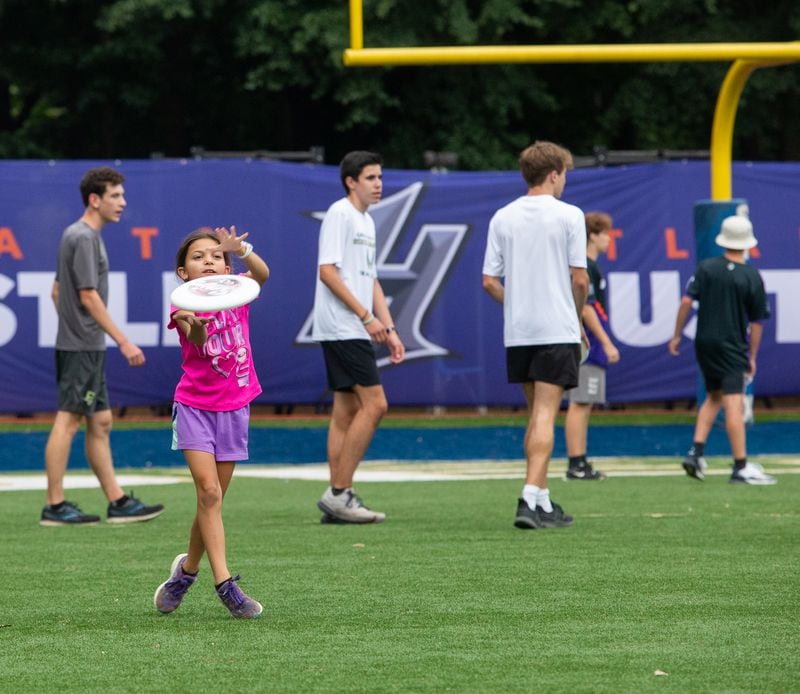 During halftime, fans, including 9-year-old Estee Litner, in pink, are allowed to come onto the field to toss a disc with the professionals.  The Hustle, Atlanta's American Ultimate Disc League team, competed against Philadelphia at St. Pius X High School Field on Saturday, June 26, 2021. Atlanta won the game 24-17.  (Jenni Girtman for The Atlanta Journal-Constitution)