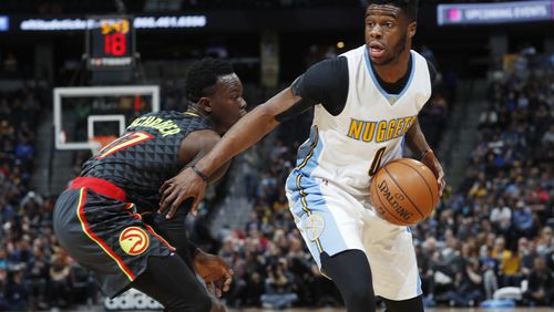 Denver Nuggets guard Emmanuel Mudiay, right, drives to the basket past Atlanta Hawks guard Dennis Schroder in the first half of an NBA basketball game Friday, Dec. 23, 2016, in Denver. (AP Photo/David Zalubowski)