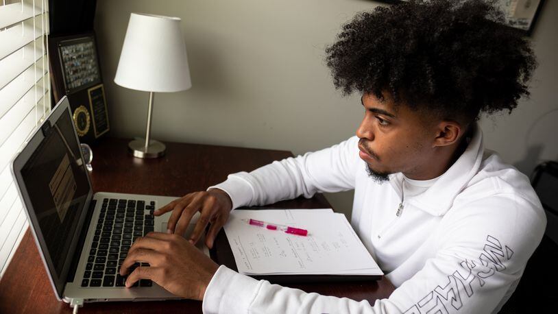 Cole Brown, a senior at South Gwinnett High School, checks through his assignments during Advanced Placement literature class on Thursday, April, 29, 2021 in his bedroom in Loganville.  Ben Gray for the Atlanta Journal-Constitution