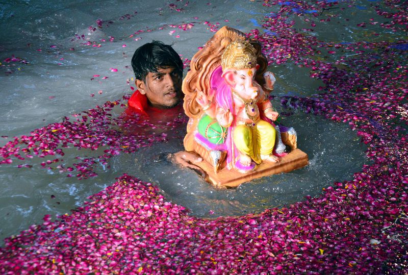 Hindu man with statue of Lord Ganesh, also called Lord Ganesha,