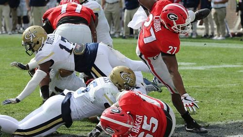 Georgia tailback Nick Chubb (27) goes over the top for a touchdown against Georgia Tech during the first quarter of an NCAA college football game on Saturday, Nov. 25, 2017, in Atlanta. (Curtis Compton/Atlanta Journal-Constitution via AP)