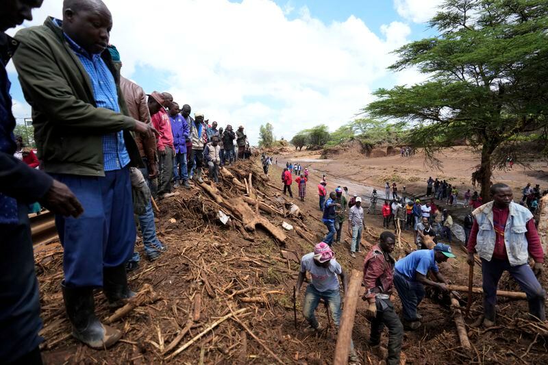 Rescuers search for bodies at a bridge where a woman's body was retrieved, after floodwater washed away houses, in Kamuchiri Village Mai Mahiu, Nakuru County, Kenya, Tuesday, April 30, 2024. Kenya, along with other parts of East Africa, has been overwhelmed by flooding that killed 66 people on Monday alone and in recent days has blocked a national highway, swamped the main airport and swept a bus off a bridge. More than 150,000 people are displaced and living in dozens of camps. (AP Photo/Brian Inganga)