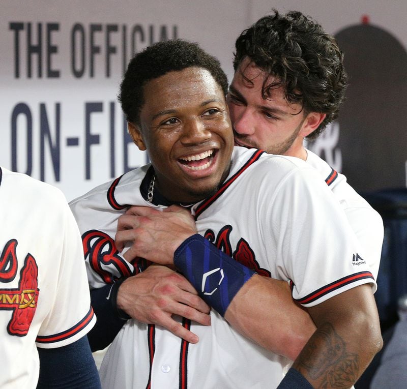 Ronald Acuna Jr. is hugged by Dansby Swanson in the dugout after his three-run homer in the seventh. Curtis Compton/ccompton@ajc.com