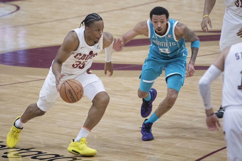 Cleveland Cavaliers' Isaac Okoro (35) is guarded by Charlotte Hornets' Nick Smith Jr. (8) during the first half of an NBA basketball game in Cleveland, Sunday, April 14, 2024. (AP Photo/Phil Long)