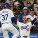 Los Angeles Dodgers' Teoscar Hernández (37) celebrates with Mookie Betts (50) after hitting a home run during the fourth inning of a baseball game against the Atlanta Braves in Los Angeles, Friday, May 3, 2024. The Braves lost 4-3.  (AP Photo/Ashley Landis)