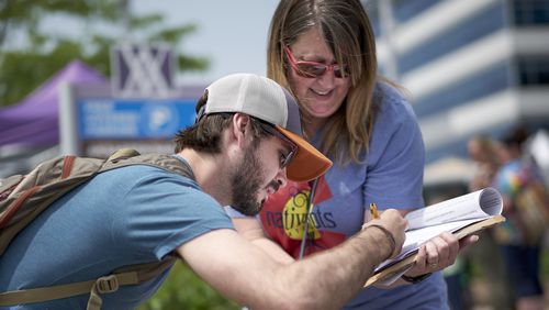 FILE- In this June 2, 2019 file photo, a volunteer in Omaha Neb., collects signatures for a petition to place a medical marijuana measure on the Nebraska 2020 ballot. Petition drives to legalize medical marijuana, allow casino gambling and lower property taxes face an uncertain future now that the new coronavirus has forced group leaders to stop collecting signatures. The groups are waiting for the pandemic to subside, but some said they still believe they can qualify for the 2020 ballot. (AP Photo/Nati Harnik, File)