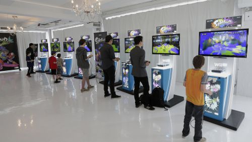 Attendees play the new "Splatoon" video game on a Nintendo Co. Wii U console at a pre-launch event in New York, U.S., on Wednesday, May 6, 2015. Nintendo Co. is scheduled to release earnings figures on May 7. Photographer: Peter Foley/Bloomberg