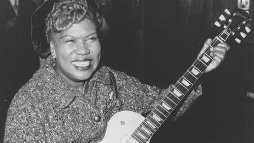 Sister Rosetta Tharpe, guitar-playing American gospel singer, gives an impromptu performance in a lounge at London Airport, following her arrival from New York on Nov. 21, 1957. AP PHOTO