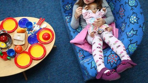 A girl plays with a baby doll at a day care center for children aged 12 months to six years on December 22, 2011 in Munich, Germany.