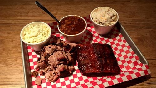 A platter of pulled pork and baby back ribs at King Barbecue is made better with sides of coleslaw, baked beans and potato salad. CONTRIBUTED BY WYATT WILLIAMS