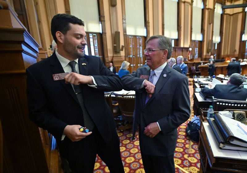 Republican state Reps. Steven Sainz  (left) and Vance Smith (right) bump elbows at the state Capitol. (Hyosub Shin/The Atlanta Journal-Constitution)