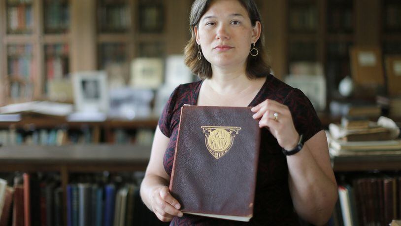 Karen Huber, Associate Professor of History at Wesleyan College, holds a 1913 yearbook titled “Ku Klux”. BOB ANDRES /BANDRES@AJC.COM