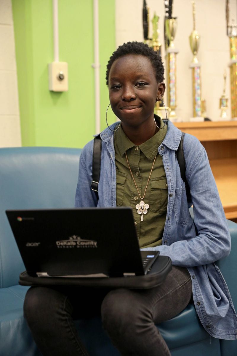  Cross Keys High School senior Joyce Korir, 17, holds her new Chromebook laptop after receiving it during the computer distribution at her school on Sept. 13, 2018, in Atlanta.  (JASON GETZ/SPECIAL TO THE AJC)