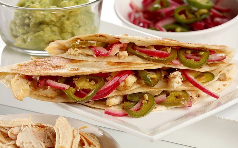 Chicken quesadillas are brightened with quick-pickled red onion and jalapenos and enriched with cheese, all folded into a tortilla. (Michael Tercha/Chicago Tribune/TNS)