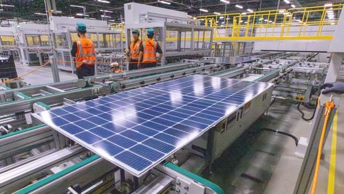 Workers keep an eye on the solar panels as they move through the automated assembly line at the Qcells module production facility in Cartersville on Tuesday, April 2, 2024.  (Steve Schaefer/steve.schaefer@ajc.com)