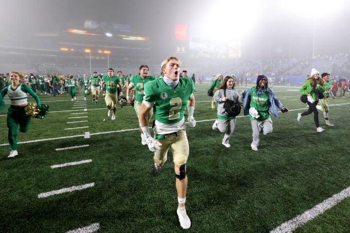 Buford's Jake Pope and others run toward their student section as they celebrate their 21-20 victory over Langston Hughes during the Class 6A state title football game at Georgia State Center Parc Stadium Friday, December 10, 2021, Atlanta. JASON GETZ FOR THE ATLANTA JOURNAL-CONSTITUTION