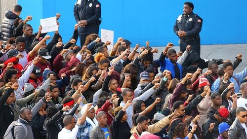 Police officers look on while Morehouse College students join others in a rally and protest at the CNN Center last year after the shooting death of Ferguson, Mo., teen Michael Brown. CURTIS COMPTON / CCOMPTON@AJC.COM