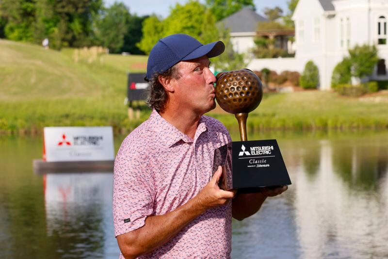 Stephen Ames kisses the trophy as he poses for the media after winning the Mitsubishi Classic senior golf tournament at TPC Sugarloaf on Sunday, April 28, 2024, in Duluth, Ga. (Miguel Martinez/Atlanta Journal-Constitution via AP)
