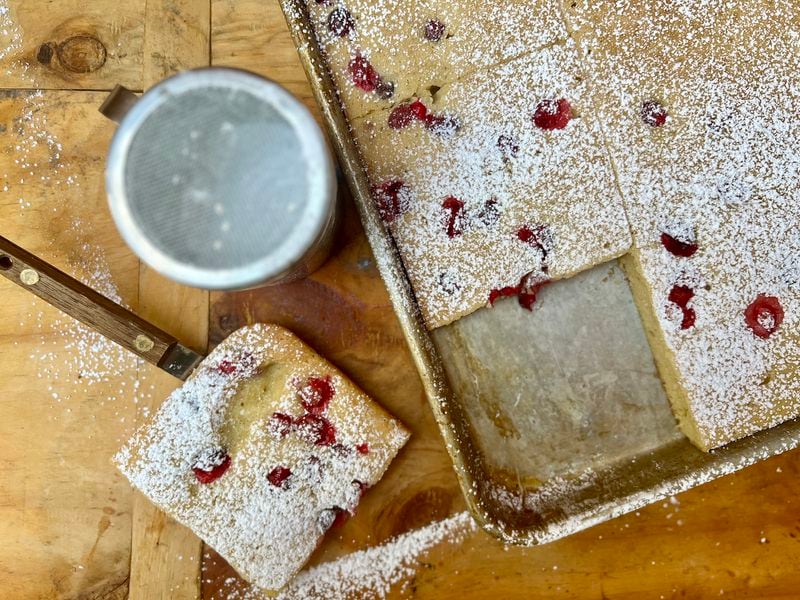 This baked buttermilk cranberry sheet pan pancake dusted with powdered sugar is an easy, elegant brunch dish to serve a crowd.
(Virginia Willis for The Atlanta Journal-Constitution)