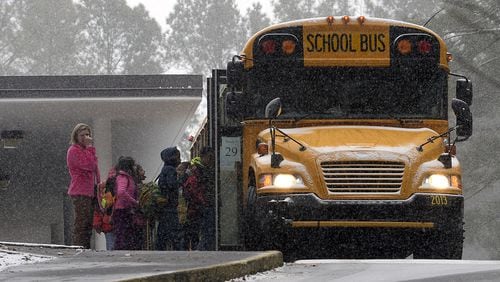 Sagamore Hills Elementary School students board a DeKalb County school bus for early dismissal as a major winter storm dumps 1 to 3 inches of snow on the metro Atlanta area, Tuesday, Jan. 28, 2014. David Tulis / AJC Special