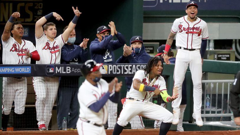 Oct. 15, 2020 - Arlington - Atlanta Braves players from left to right; Cristian Pache, Austin Riley, Ronald Acuna, and Johan Camargo react after designated hitter Marcell Ozuna (not pictured) hit a RBI double against the Los Angeles Dodgers during the sixth inning in Game 4 Thursday, Oct. 15, 2020, for the best-of-seven National League Championship Series at Globe Life Field in Arlington, Texas. (Curtis Compton / Curtis.Compton@ajc.com)
