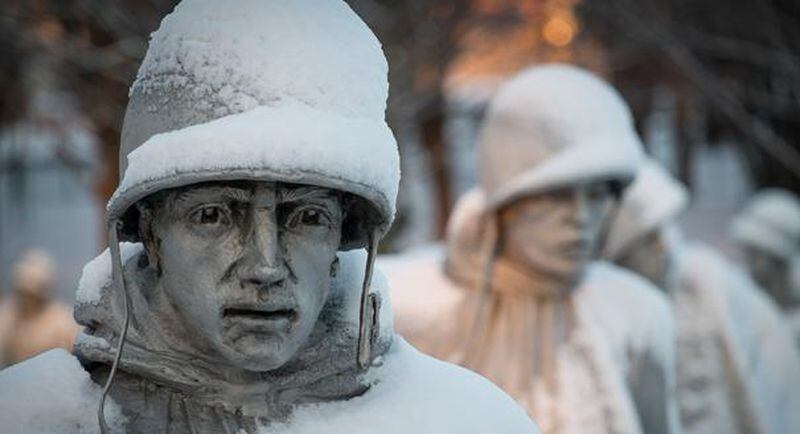 A light dusting of snow from an overnight storm covers the statutes at the Korean War Memorial in Washington early Friday morning Jan. 3, 2014. After a storm blew through the Washington region overnight, roads are being cleared and many schools systems are closed. The federal government and the District of Columbia government will be open Friday, but workers have the option to take leave or telework. (AP Photo/J. David Ake)