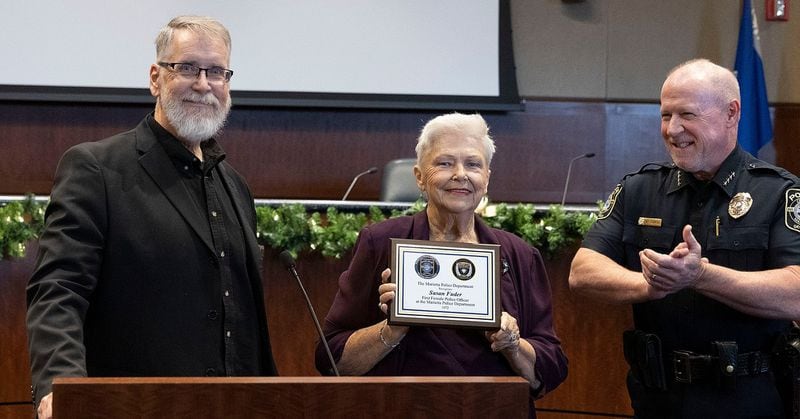 Susan Fuder was recently honored for being the first female police officer for Marietta. At right is police Chief Marty Ferrell and retired Sgt. Jack Shields is on the left.