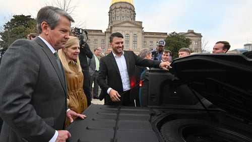 December 16, 2021 Atlanta - Jimmy Knauf EVP of Facilities at Rivian, smiles as he shows Rivian R1T electric truck to Georgia Governor Brian Kemp (left) and First Lady Marty Kemp (second from left) during a press conference at Liberty Plaza across from the Georgia State Capitol in Atlanta on Thursday, December 16, 2021. Electric vehicle maker Rivian on Thursday confirmed its plans to build a $5 billion assembly plant and battery factory in Georgia, which Gov. Brian Kemp called "the largest single economic development project ever in this state's history." (Hyosub Shin / Hyosub.Shin@ajc.com)