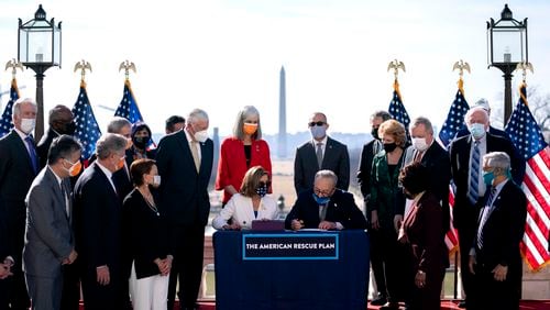 House Speaker Nancy Pelosi (D-Calif.), watches Senate Majority Leader Chuck Schumer (D-N.Y.), sign the COVID-19 relief bill during an enrollment ceremony outside the Capitol in Washington, with the Washington Monument in the background, on Wednesday, March 10, 2021. Congress gave final approval on Wednesday to President Joe Biden’s sweeping, nearly $1.9 trillion stimulus package, as Democrats acted over unified Republican opposition to push through an emergency pandemic aid plan that included a vast expansion of the country’s social safety net. (Stefani Reynolds/The New York Times)