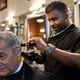 Barber Therelle Lewis gives Joe King, another barber, a trim at Off the Hook Barber Shop in Atlanta on Thursday, May 9, 2024. (Arvin Temkar / AJC)