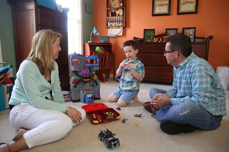 Tammy and Mat Davis play with their 5-year-old son, Joshua, at their Johns Creek home June 27, 2017, but the family is also facing a serious situation together: Mat, 55, has Alzheimer’s disease. CONTRIBUTED BY JASON GETZ