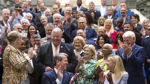 Georgia Gov. Brian Kemp, front left, and first lady Marty Kemp, applaud Tuesday after the governor signed a $36.1 billion budget for fiscal year 2025, which begins July 1. The plan anticipated slow tax collections, following a trend that began in 2023. (John Spink/Atlanta Journal-Constitution via AP)