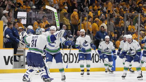 Vancouver Canucks goaltender Arturs Silovs (31) and defenseman Carson Soucy (7) celebrate the team's 4-3 overtime win against the Nashville Predators in Game 4 of an NHL hockey Stanley Cup first-round playoff series Sunday, April 28, 2024, in Nashville, Tenn. (AP Photo/George Walker IV)