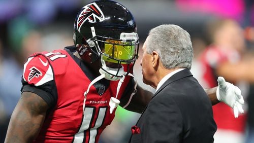 Julio Jones gives Falcons owner Arthur Blank a hug before a game against Dallas last season. Blank has promised “work will be done” on Jones’ contract.