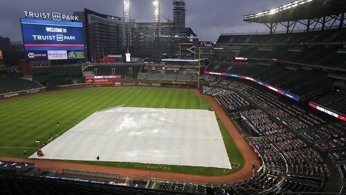 092420 Atlanta: Members of the Atlanta Braves ground crew adjust the infield tarp during a rain delay before playing the Miami Marlins in a MLB baseball game on Thursday, Sept. 24, 2020 in Atlanta.   “Curtis Compton / Curtis.Compton@ajc.com”