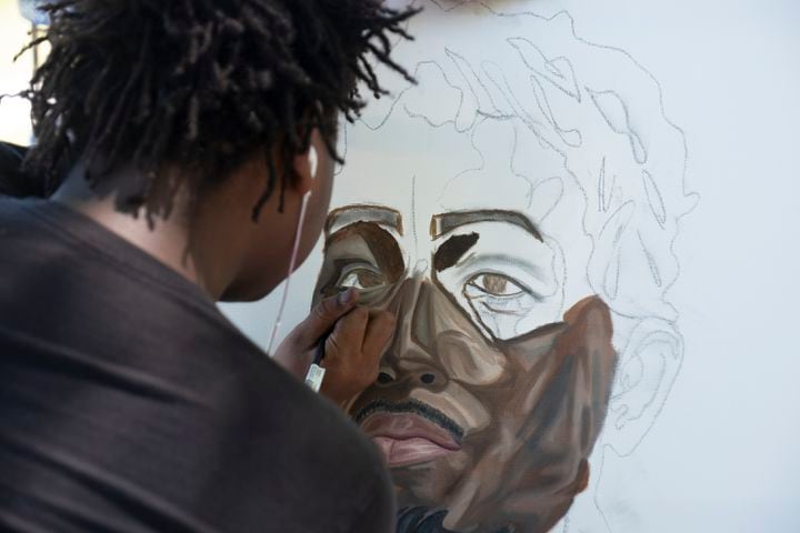 Arthur Ruby works on a portrait of Jean Baptiste Point du Sable, the founder of Chicago, while at his mentor’s booth at the Dogwood Festival in Piedmont Park on Saturday, April 13, 2024.   (Ben Gray / Ben@BenGray.com)