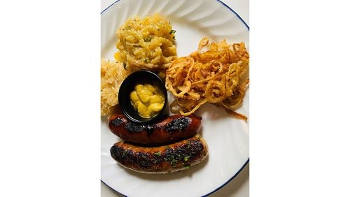 Kurt's offers a sausage skillet with sauerkraut, German potato salad and onion straws. Bob Townsend/For The AJC