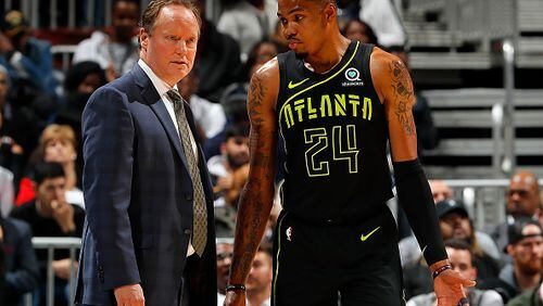 Hawks coach Mike Budenholzer discusses a no doubt difficult situation with Kent Bazemore. (Kevin C. Cox/Getty Images)