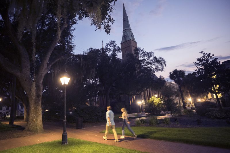 SAVANNAH, GA - AUGUST 19, 2023: A couple walks through the square formerly known as Calhoun Square in the heart of the landmark historic district, Saturday, Aug. 19, 2023, in Savannah, Georgia. (AJC Photo/Stephen B. Morton)