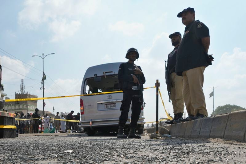 Police officers stand guard at the site of suicide attack in Karachi, Pakistan, Friday, April 20, 2024. Five Japanese nationals traveling in a van narrowly escaped a suicide attack when a suicide bomber detonated his explosive-laden vest near their vehicle in Pakistan's port city of Karachi on Friday, wounding three passers-by, police said. (AP Photo/Fareed Khan)