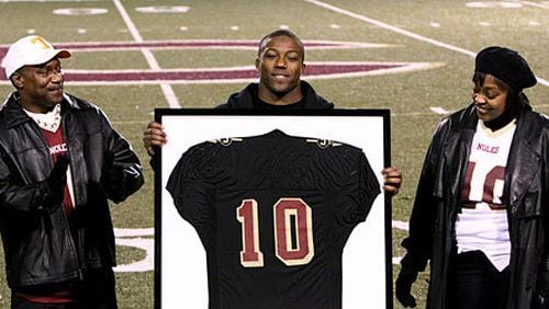 Former Creekside star quarterback Eric Berry, with proud parents James and Carol, accepts his jersey -- the first to be retired by the Seminoles in over 20 years.